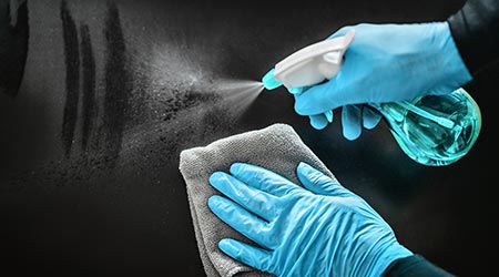  Surface cleaning disinfecting home with sanitizing antibacterial wipes protection against COVID-19 spreading wearing medical blue gloves. Sanitize surfaces prevention in hospitals and public spaces.
