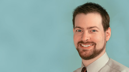 Bearded man smiles why wearing tie and collared shirt