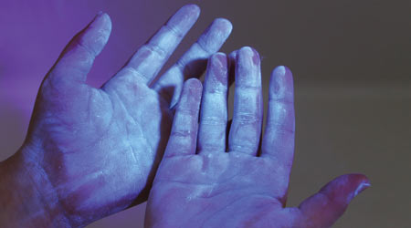 dirty contaminated hands under blacklight