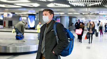 European man wearing a mask at the airport