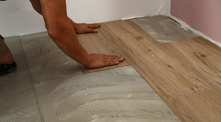 worker installing new vinyl tile floor