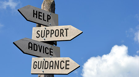 wooden signpost with arrows pointing to help, support, advice and guidance 