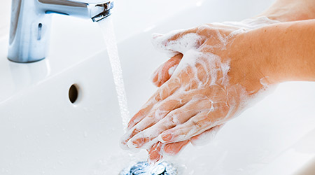 women washing her hands with soap and water