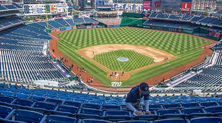 Washington, DC, 05 16 19. An usher cleans seats before the start of a Washington Nationals baseball game at Nationals Park in Washington, DC.